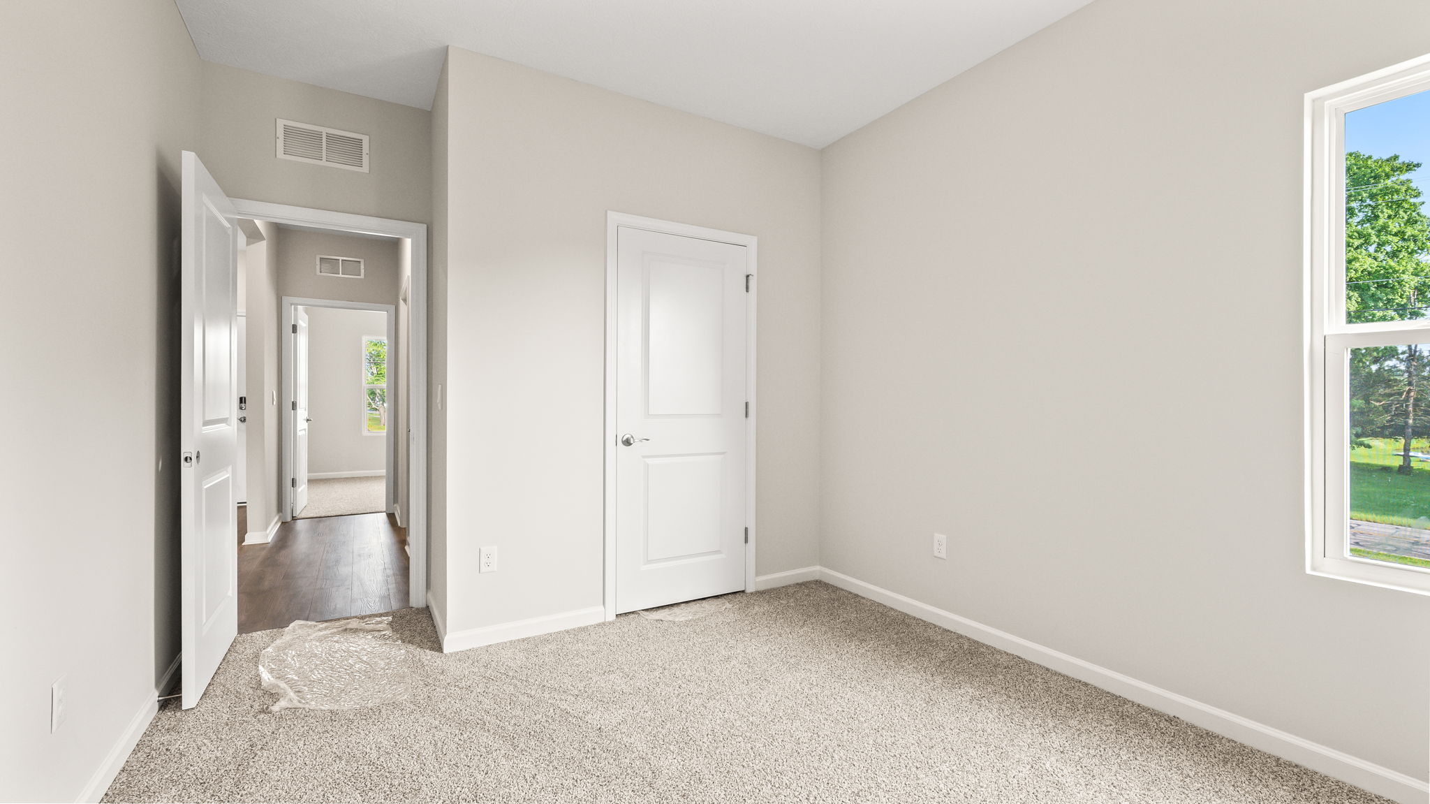 Carpeted bedroom with window and closet
