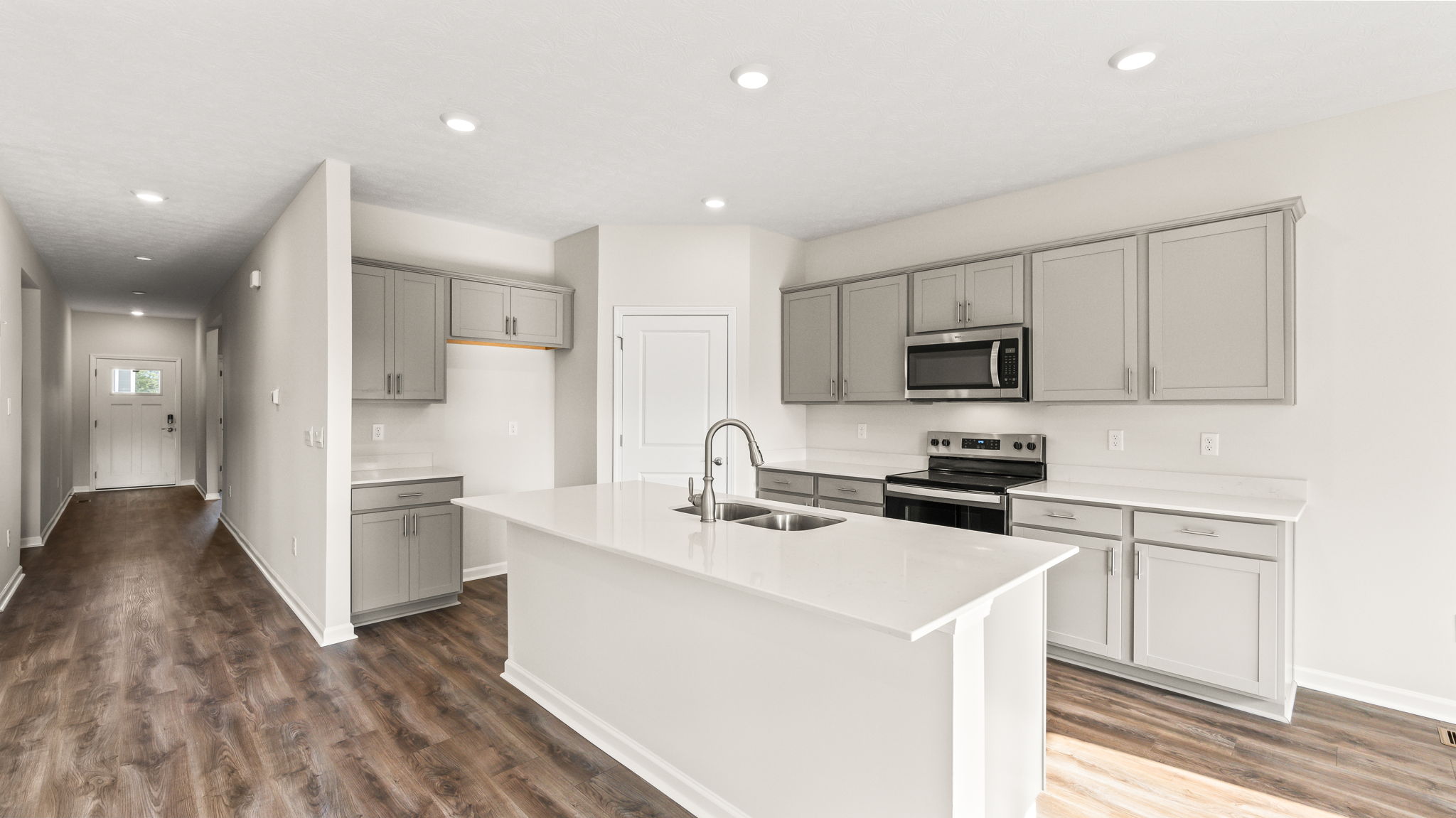 Wide angle image of kitchen with island and appliances