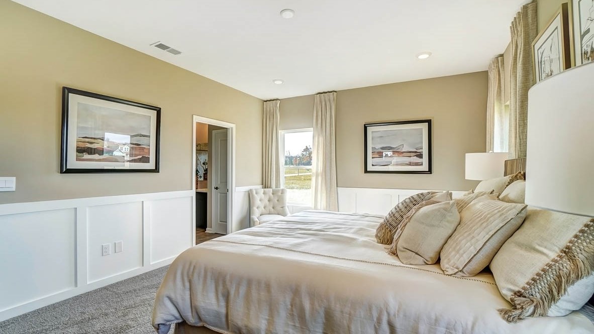 Modern art side view of bedroom and reading chair in primary bedroom.