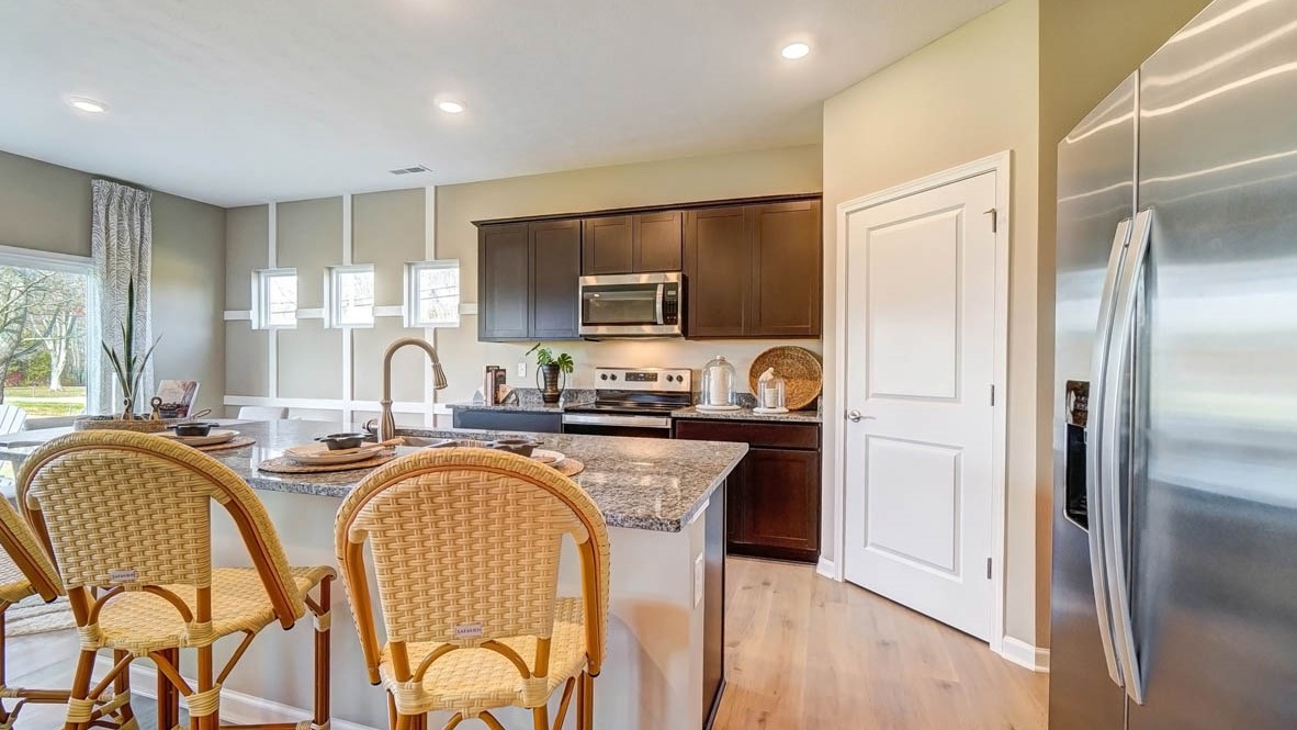 Large kitchen with wickered chairs and large kitchen island