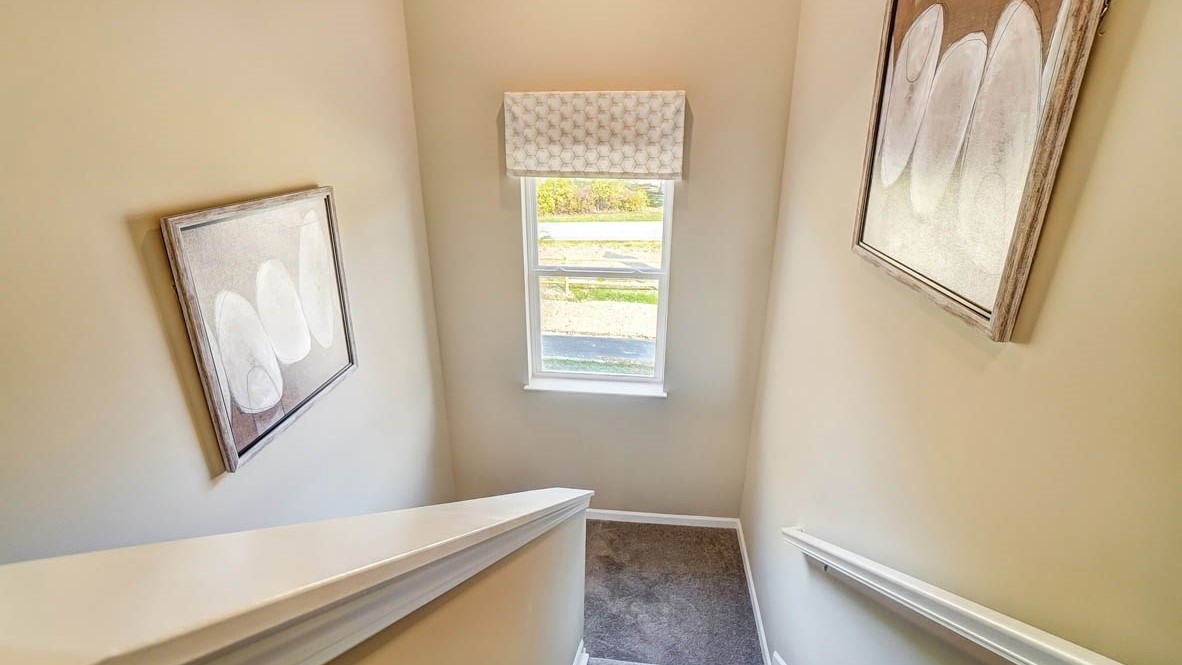 top of stairs with modern art and window.