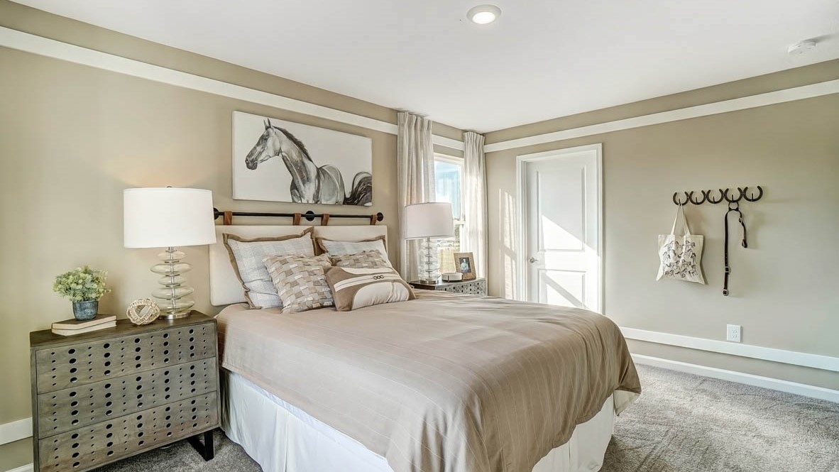 bedroom with bedside table, large bed, and decorative hooks.