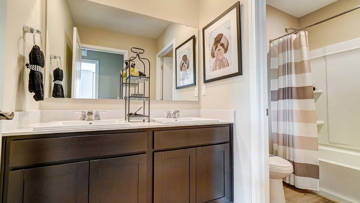shared bathroom with dual vanity sinks and modern art
