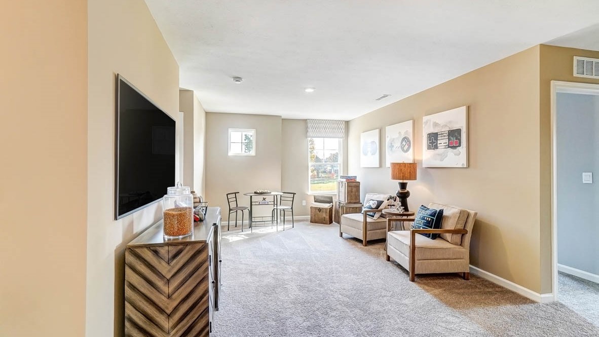 loft with tv, comfortable seating, and warm natural light.