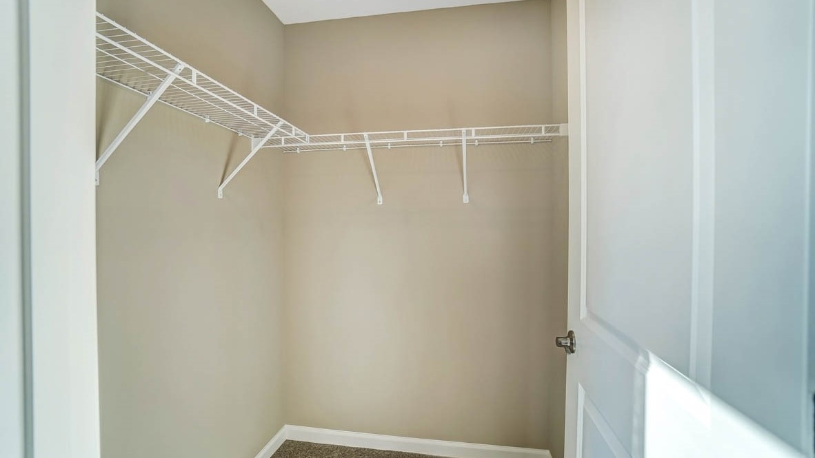 closet attached to bedroom with lots of shelve space.