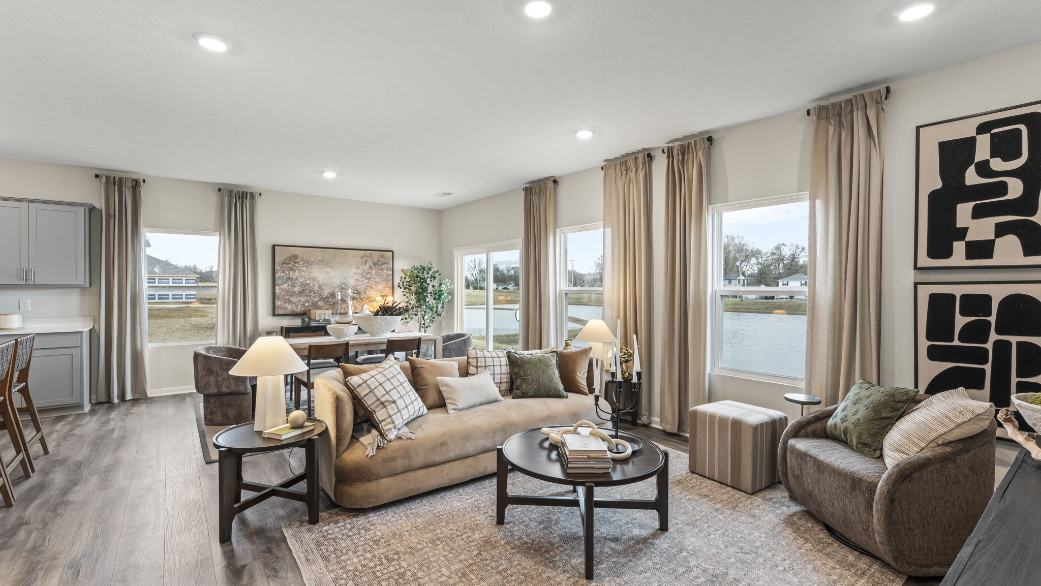 Full living room with coffee table, contemporary art, and dining room in background.