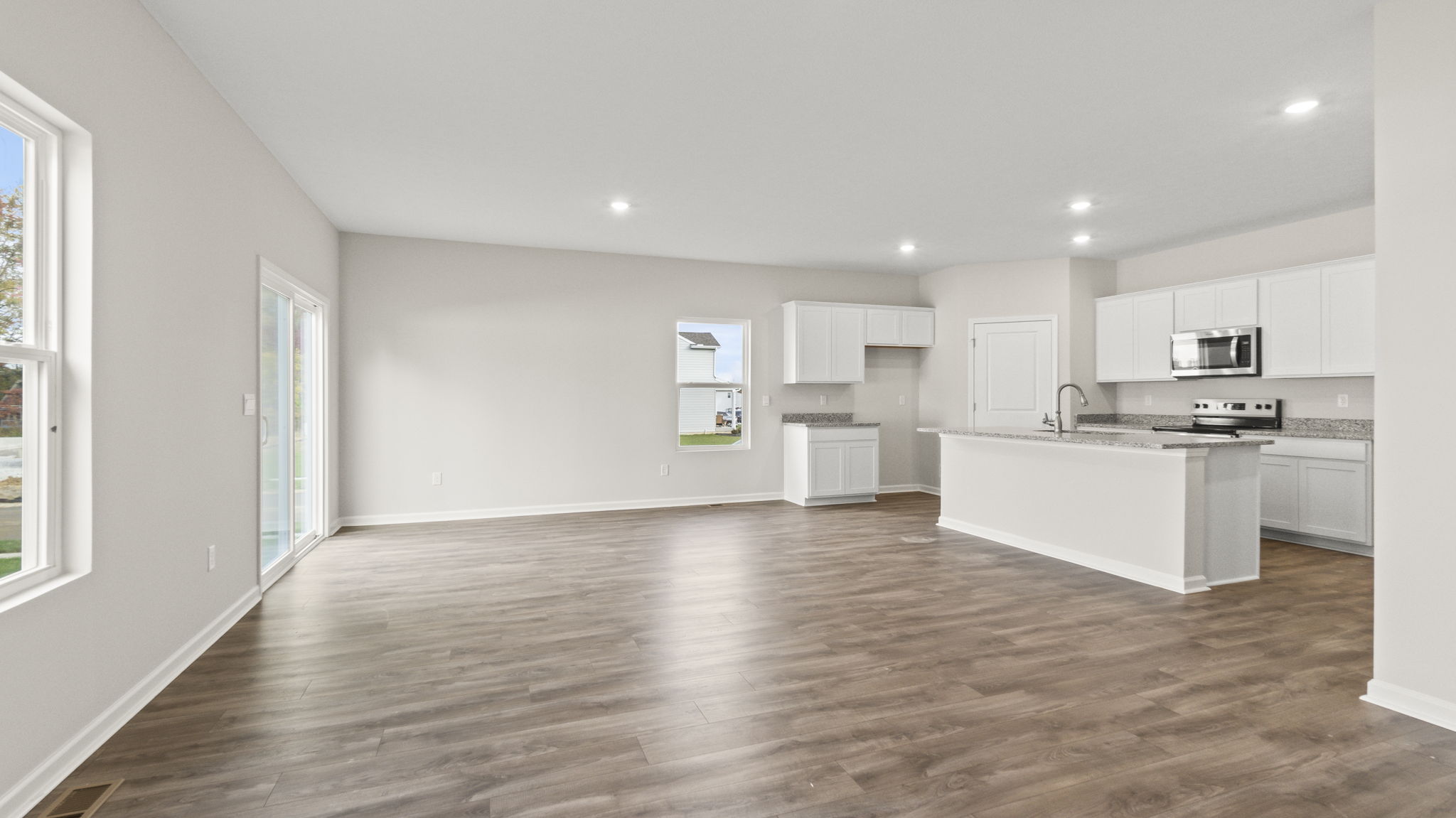 Full great area looking into kitchen with granite countertops
