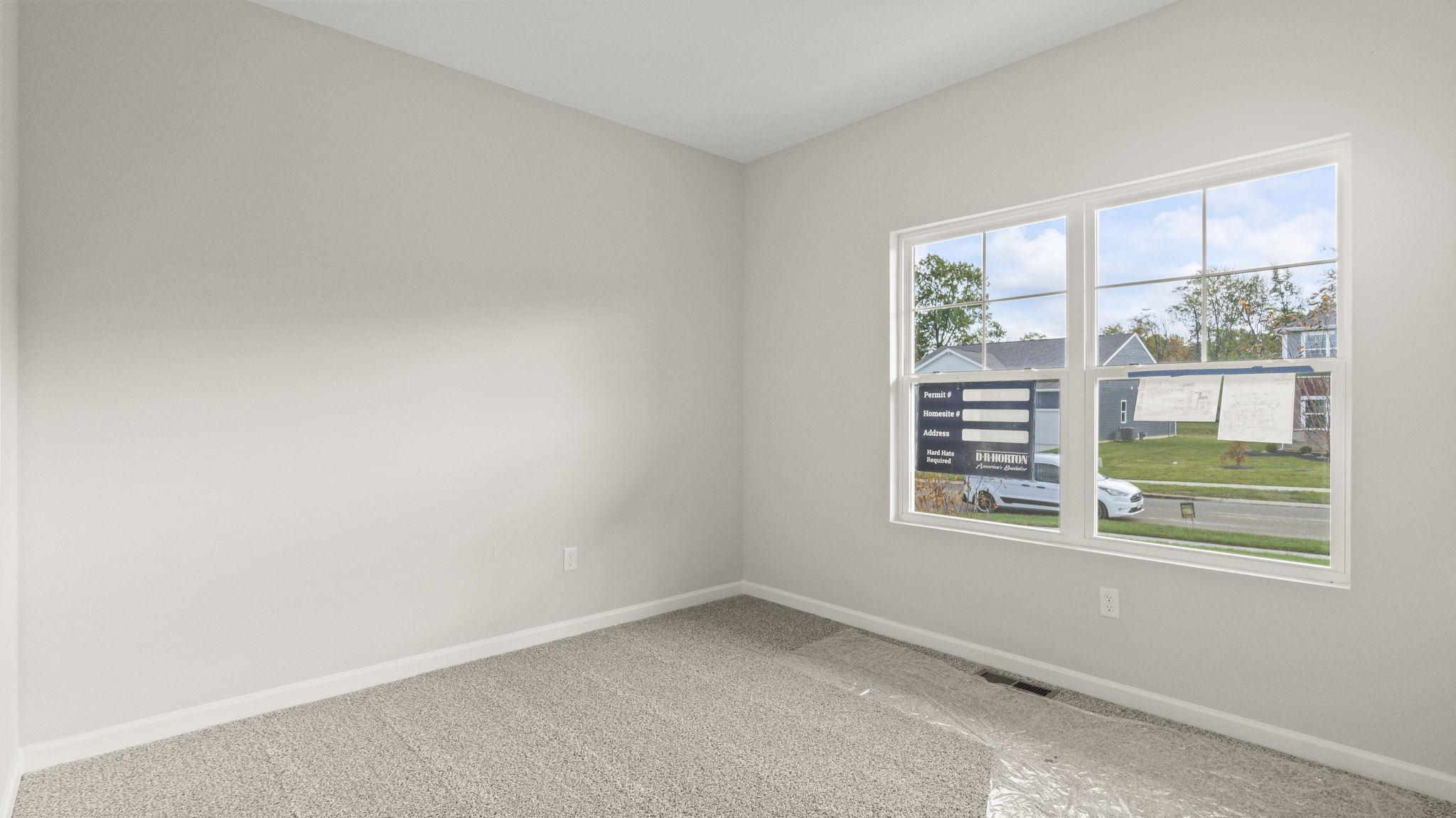 Carpeted bedroom at the front of the home with window looking outside