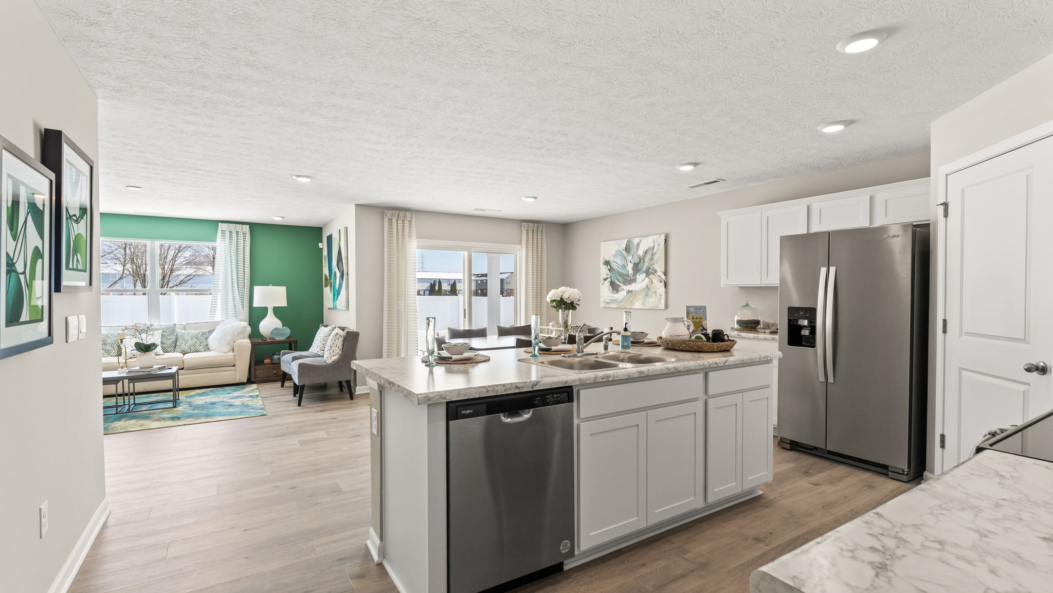 Wide perspective shot of the kitchen island from the island with view of modern dining area