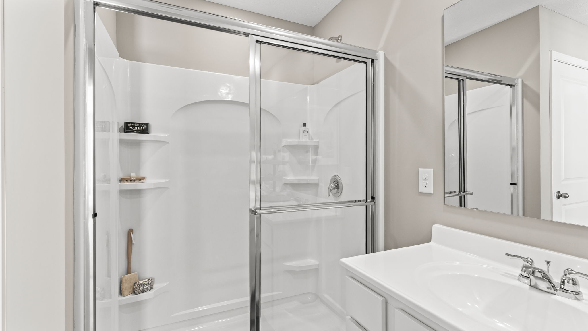 closeup of shower with tiered shelving and glass door upgrade