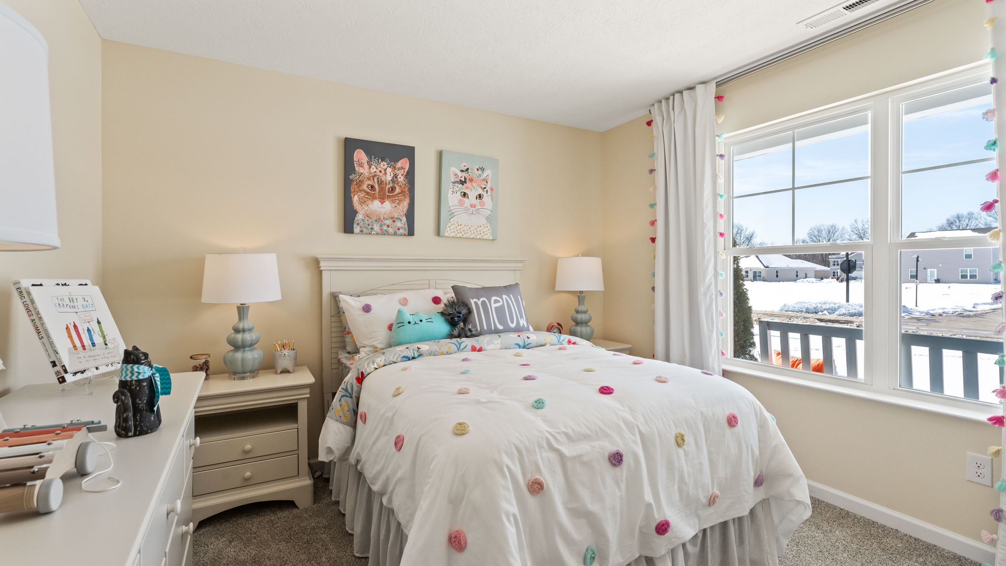 Wide image of bedroom with light airy decorations