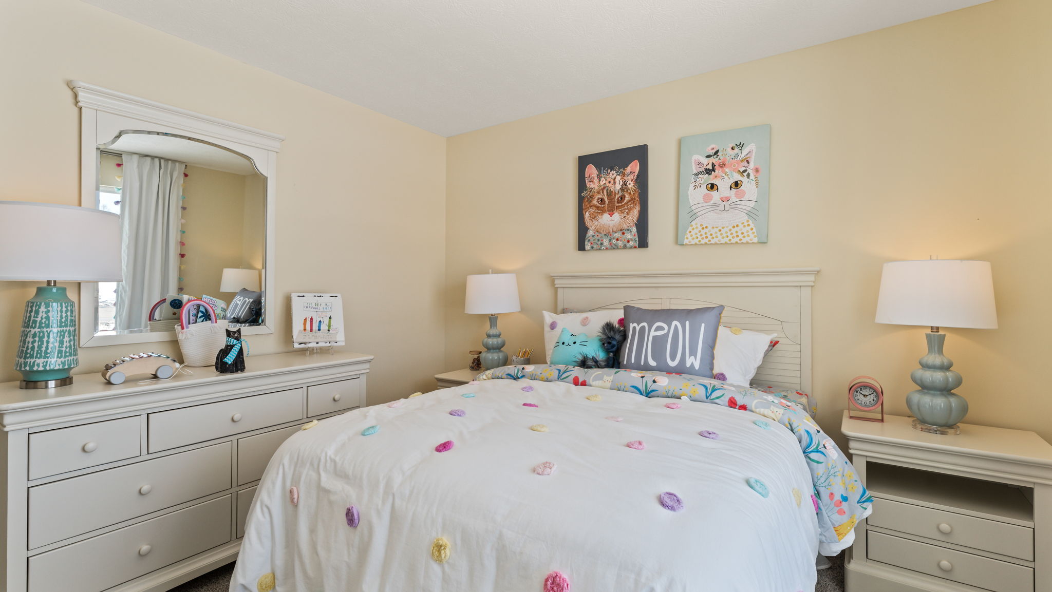 Wide image of bedroom with light airy decorations