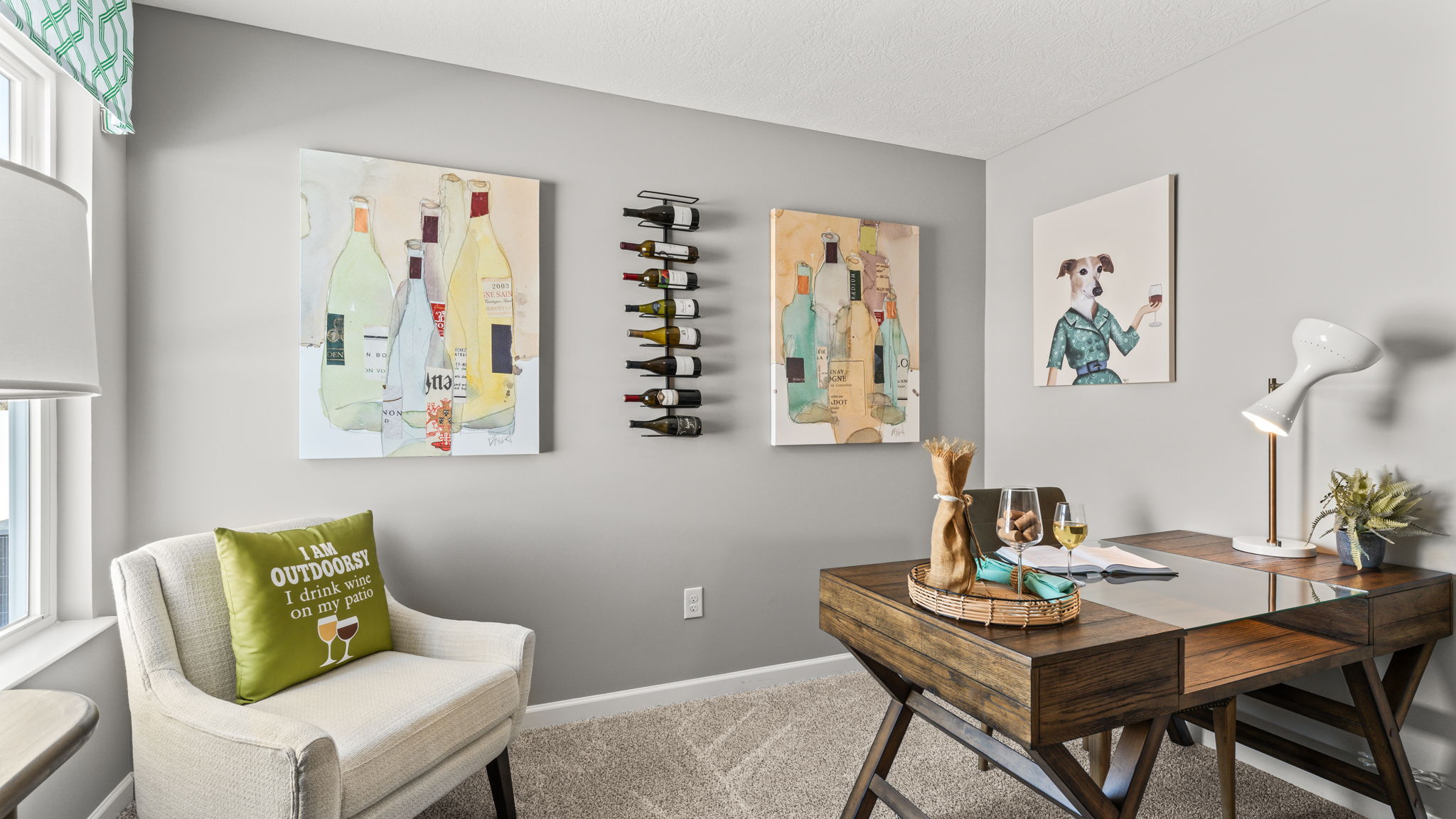 Office room with contemporary art on walls, brown wooden table, white chair, and white walls.