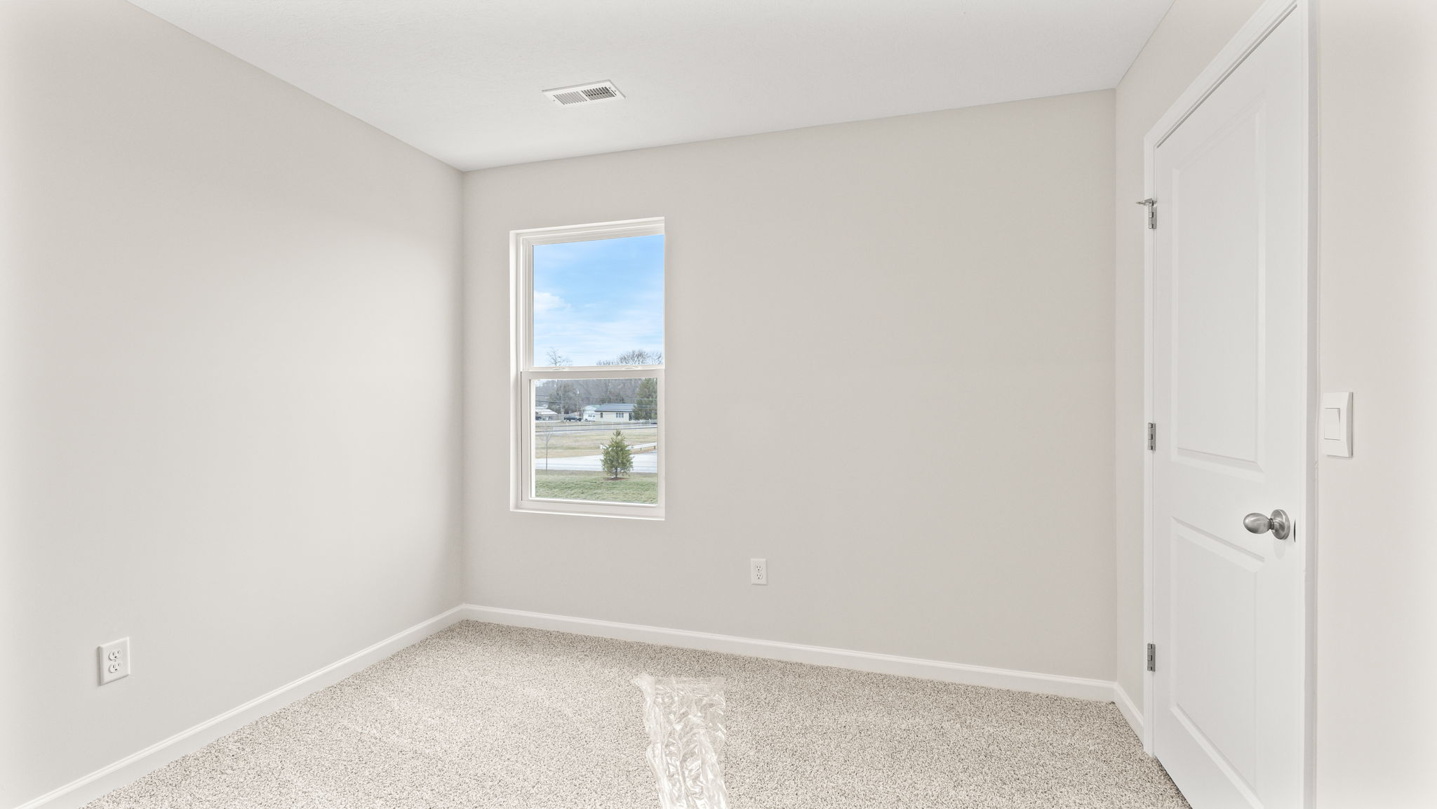 wide angle image  of bedroom with carpet and window