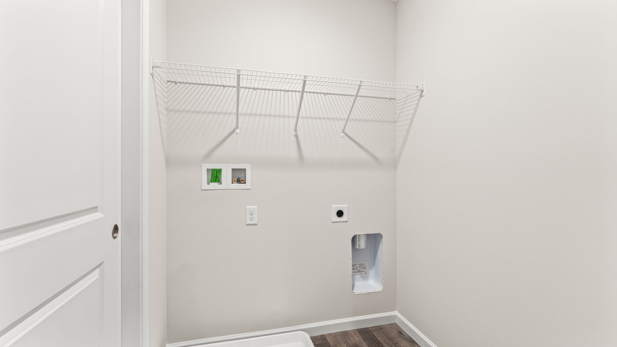 Laundry area with washer/dryer inlets and wire rack shelving