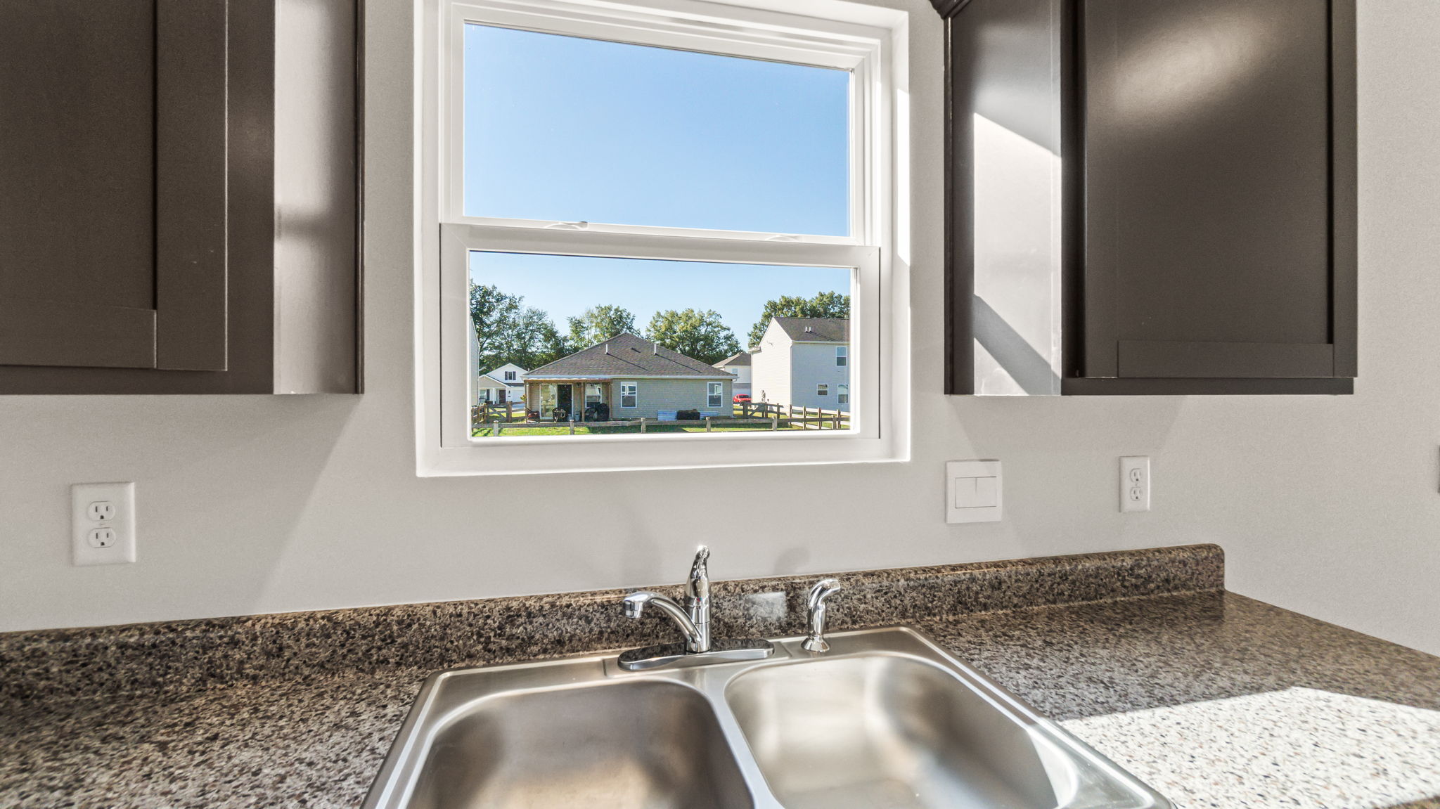 Closeup of kitchen sink with view of outdoors with window