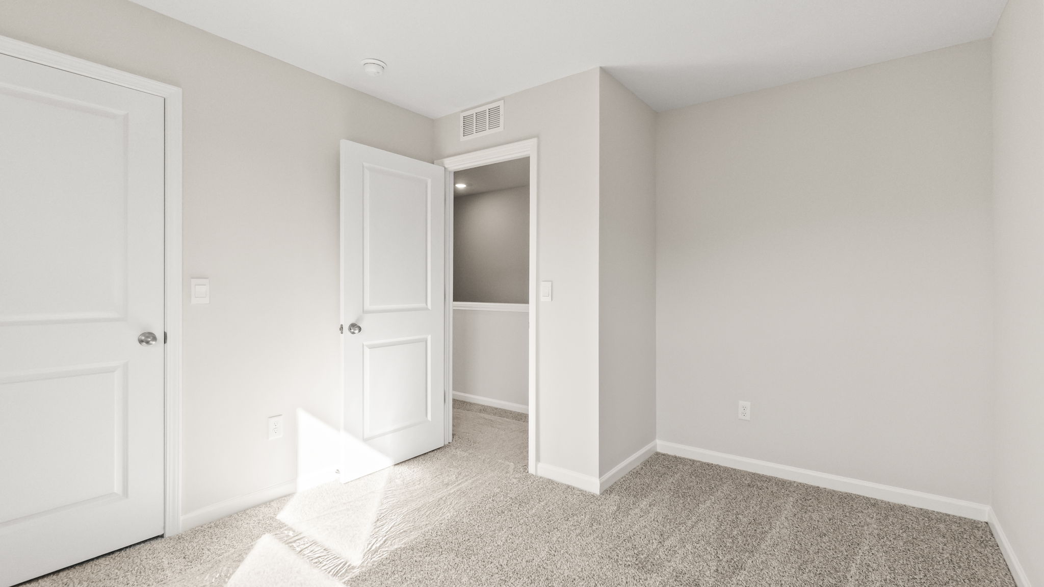 carpeted bedroom with door to hallway