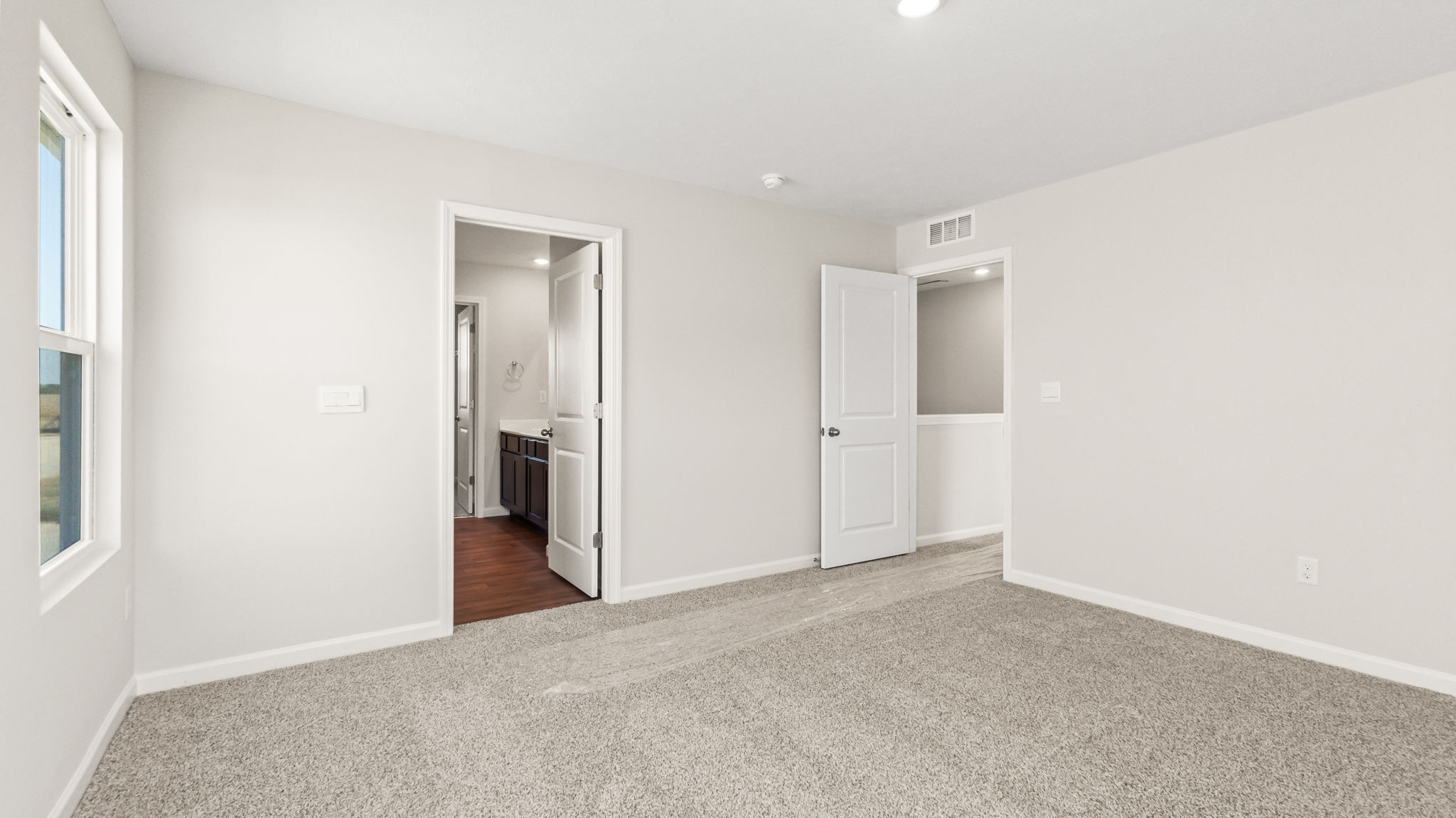 carpeted bedroom with door to hallwau
