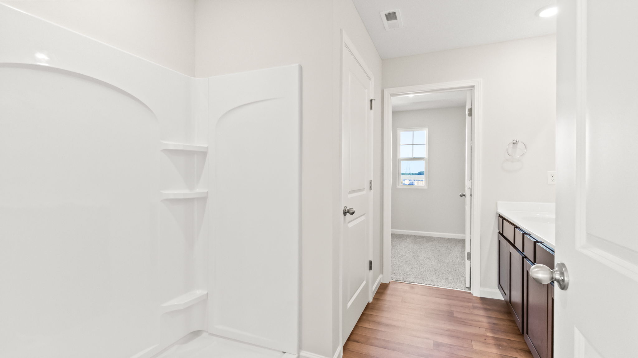 bathroom suit with walk-in shower, storage room, and sink