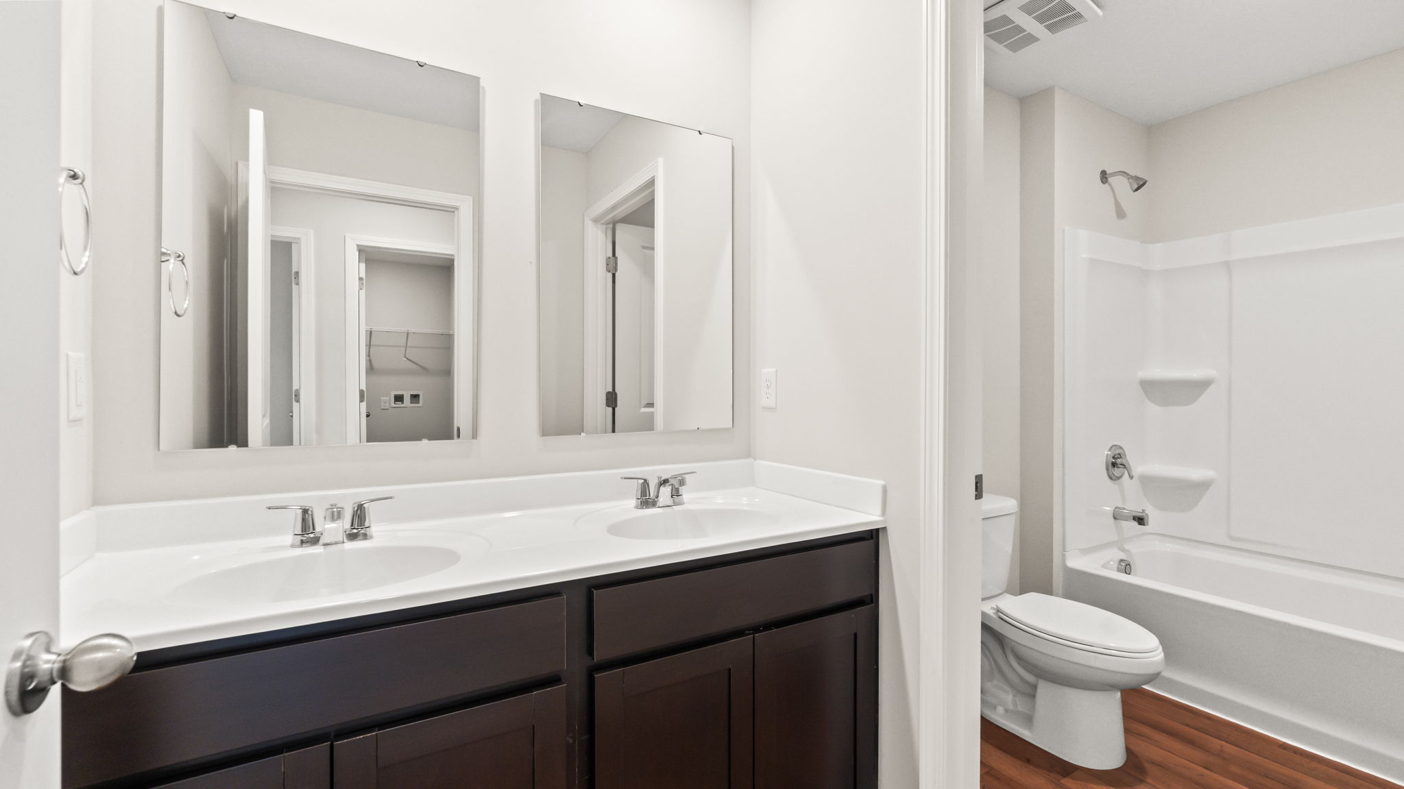 Bathroom with doble bowl vanity, toilet, and tub