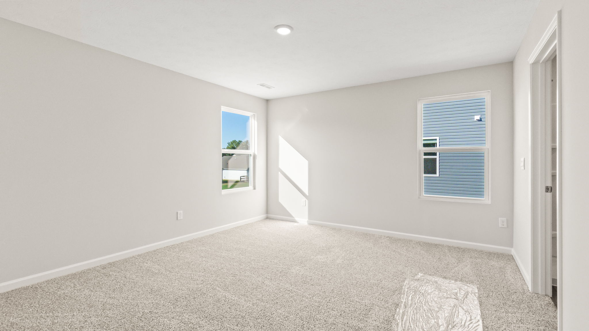 Carpeted primary bedroom with tow windows