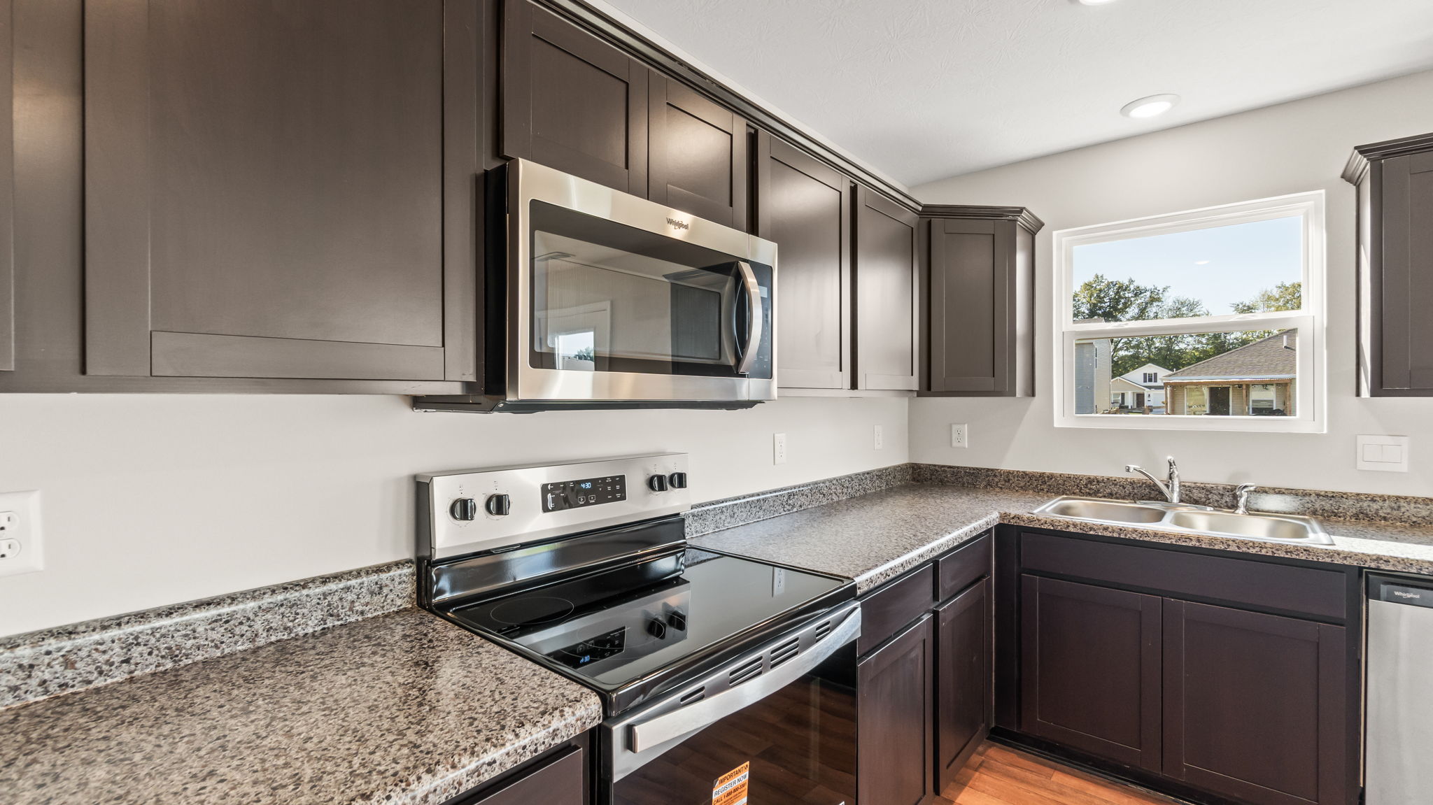 Closeup of oven range and microwave between counteropts and cabinetry
