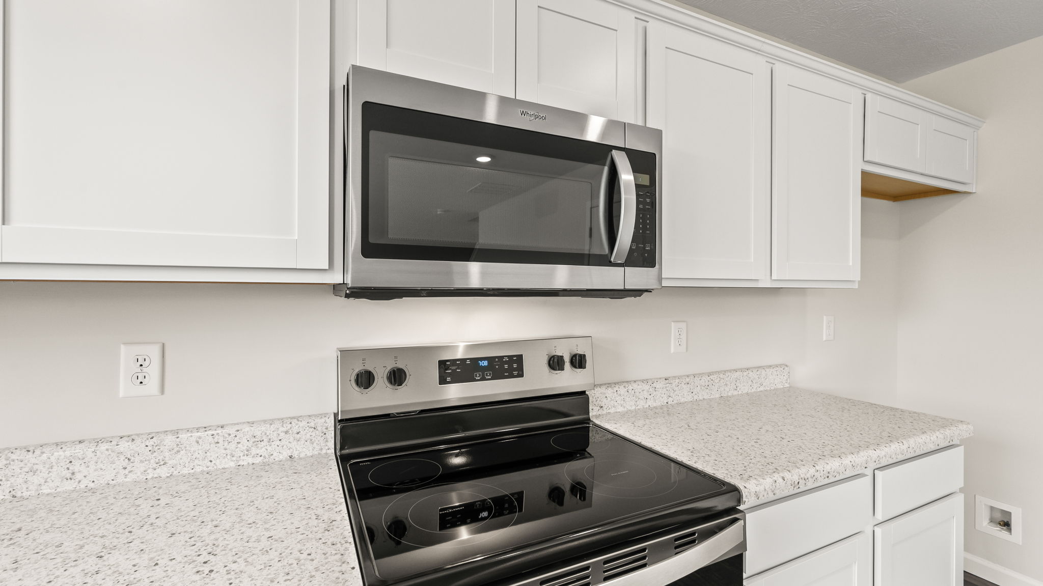 Closeup of oven range and microwave inbetween countertops