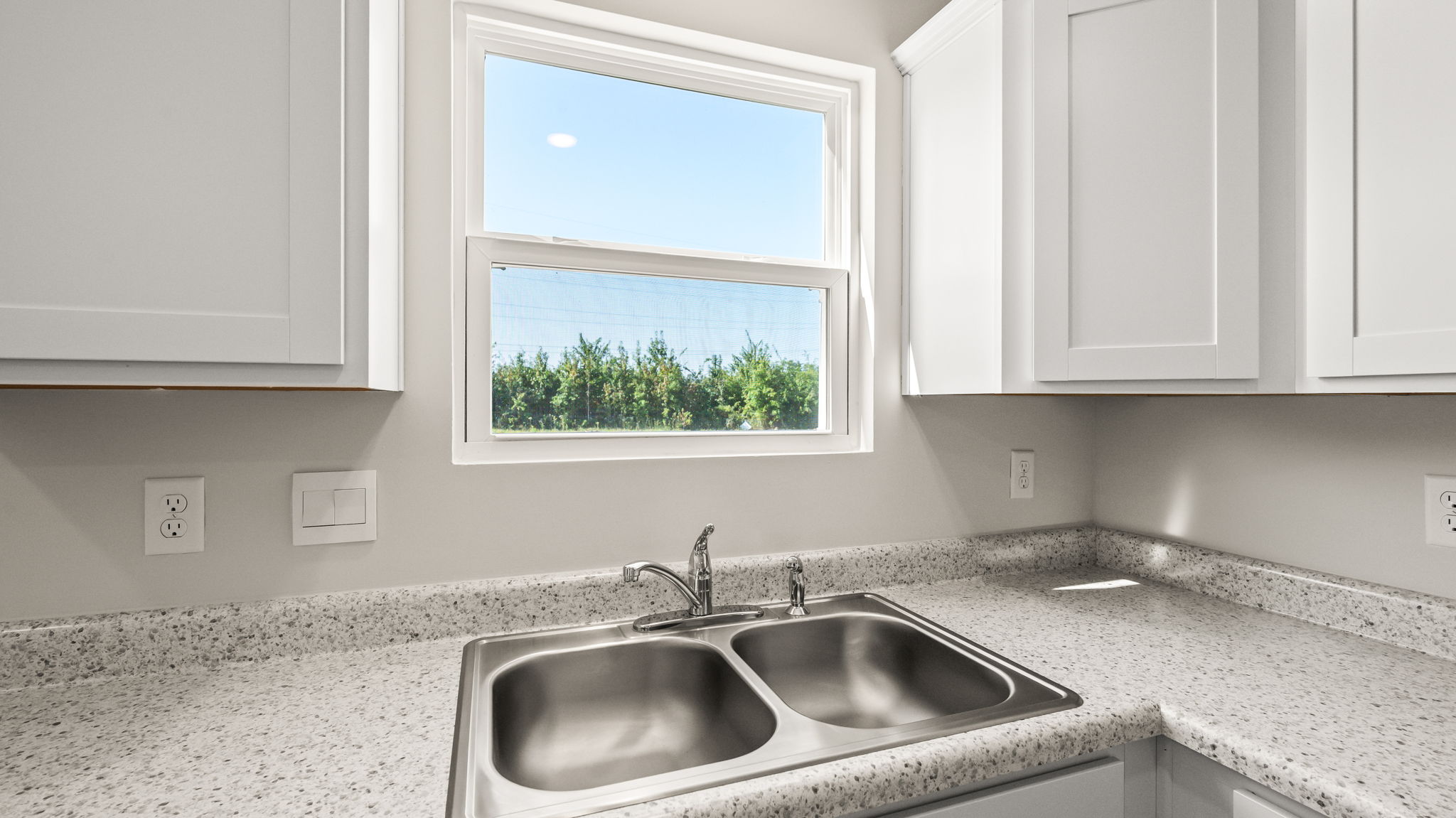 Closeup of kitchen sink with view of outdoor window