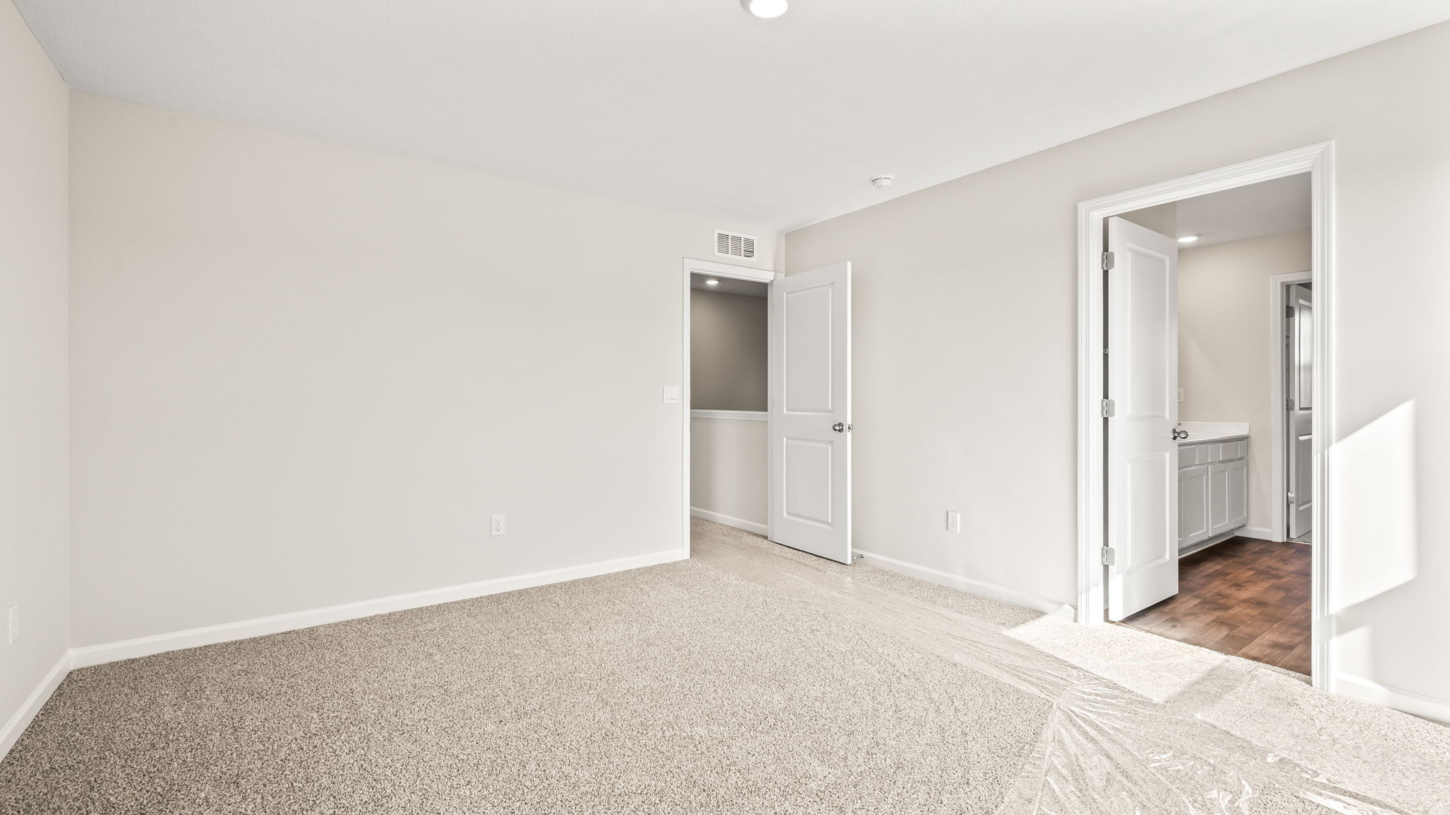 Primary door to primary bathroom suite visible