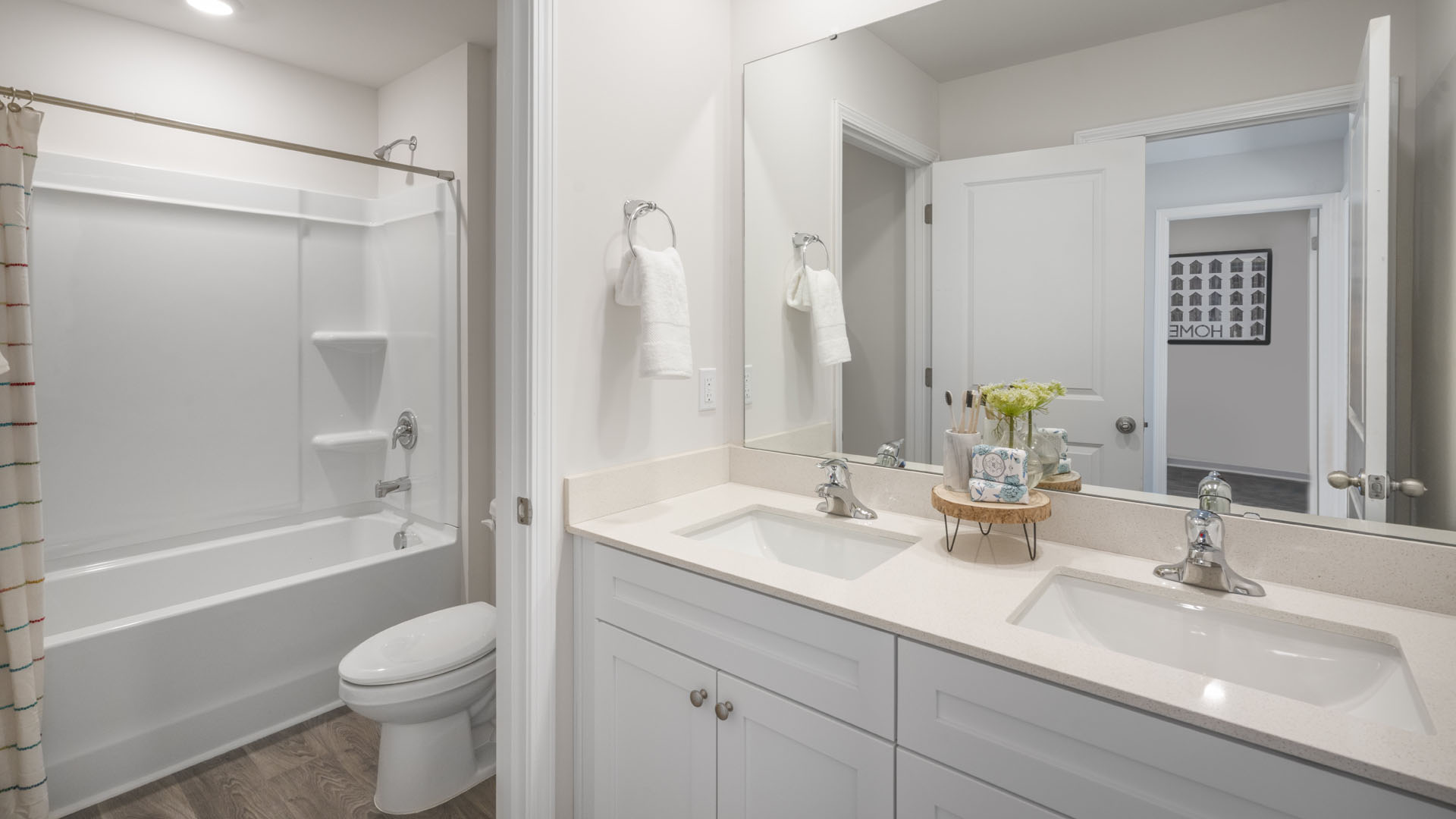 Shared bathrom with dual vanity sinks and separate shower and toilet room.