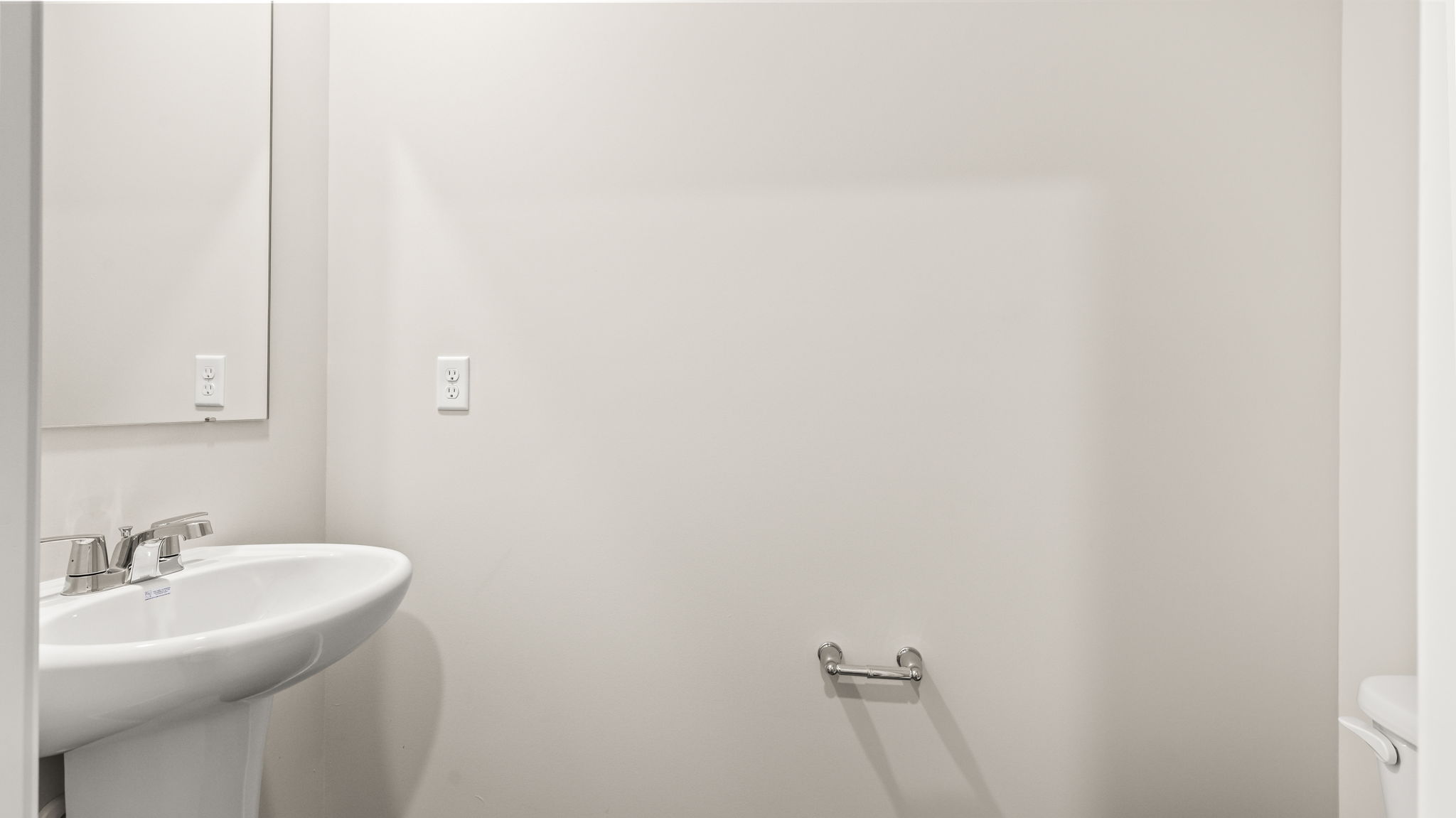 Powder room with sink, mirror, and toilet