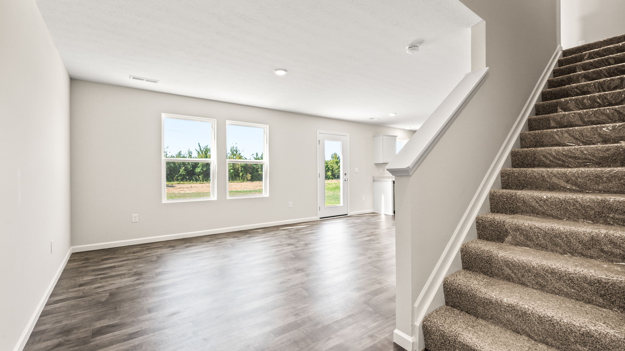 Hallway leading into great room with stairs on rightside of frame