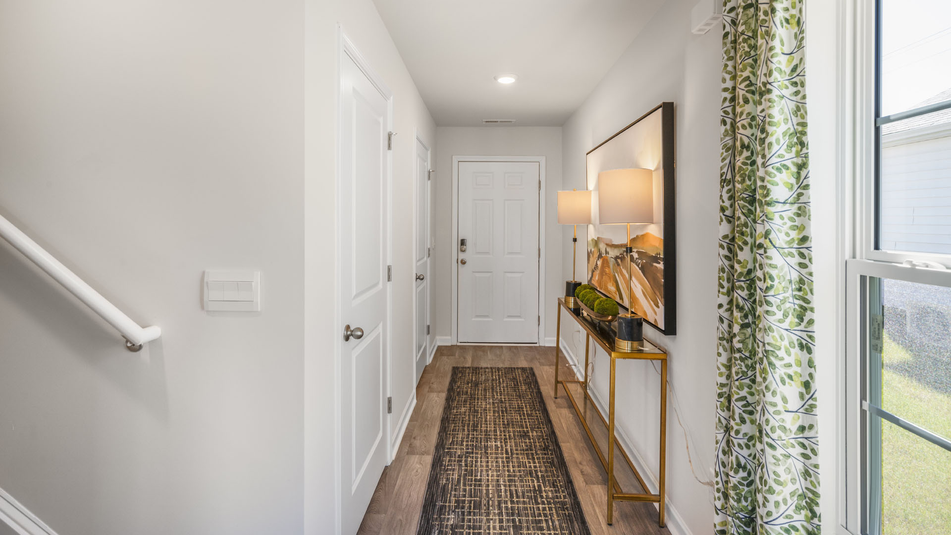 front hallway with modern art and long side table.