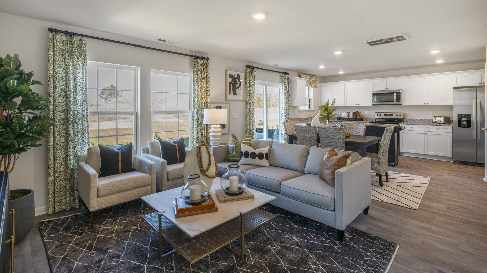 Modern open concept great room with large windows and beautiful décor.