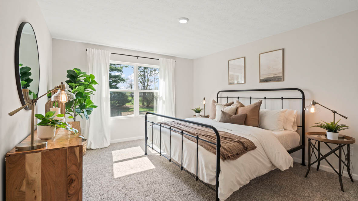Primary Bedroom with large king size bed large windows and matching bedside tables.