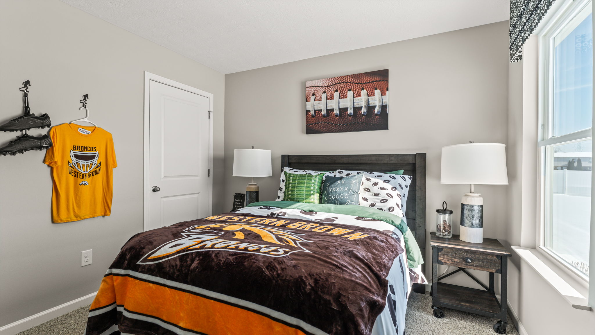 Wide image of a bedroom with sports theme