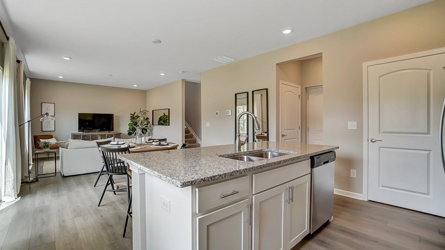 Full shot of great room with kitchen island, dining room, and living room.
