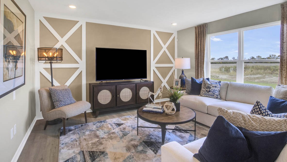 Living room with modern decoration, window to the outside, and neutral tone carpet