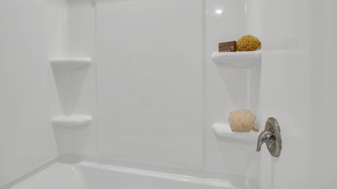 Closeup of tub and shower with tiered shelving