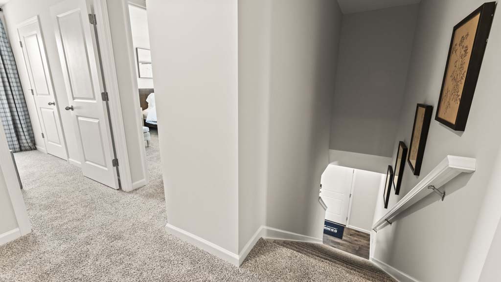 Second level hallway with view of two of the bedrooms and laundry area