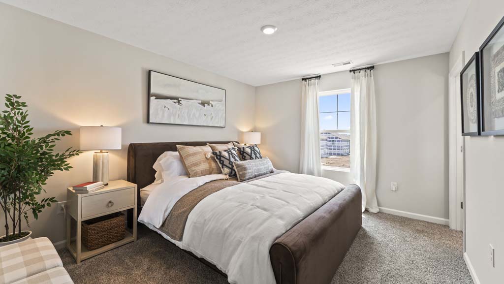 Primary bedroom with brown, tan, and beige bedding with abstract art on wall