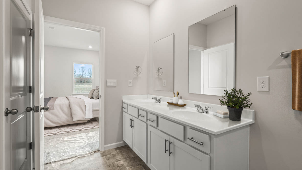 Primary Bathroom with dual vanity sinks and view of primary bedroom.