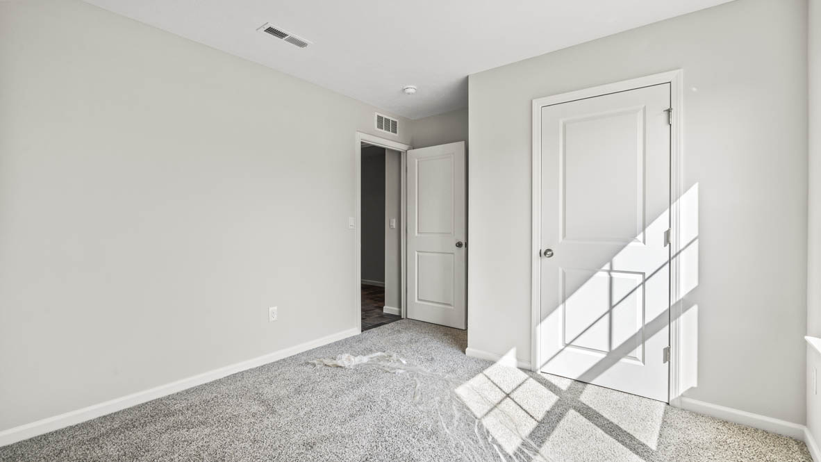 Carpeted bedroom with closet