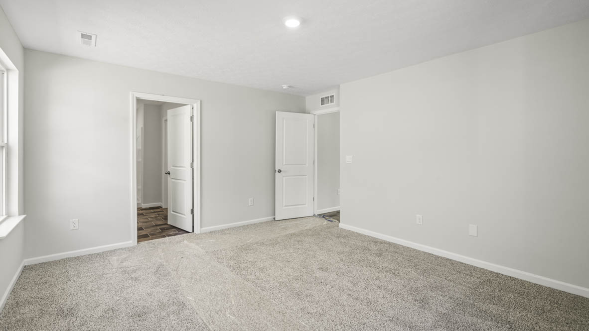 Primary bedroom with view of primary bathroom