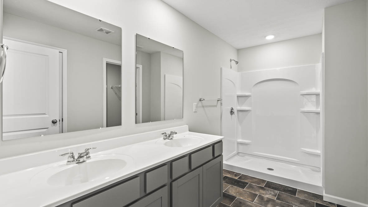 Primary bathroom with dual-sink vanity and walk-in shower