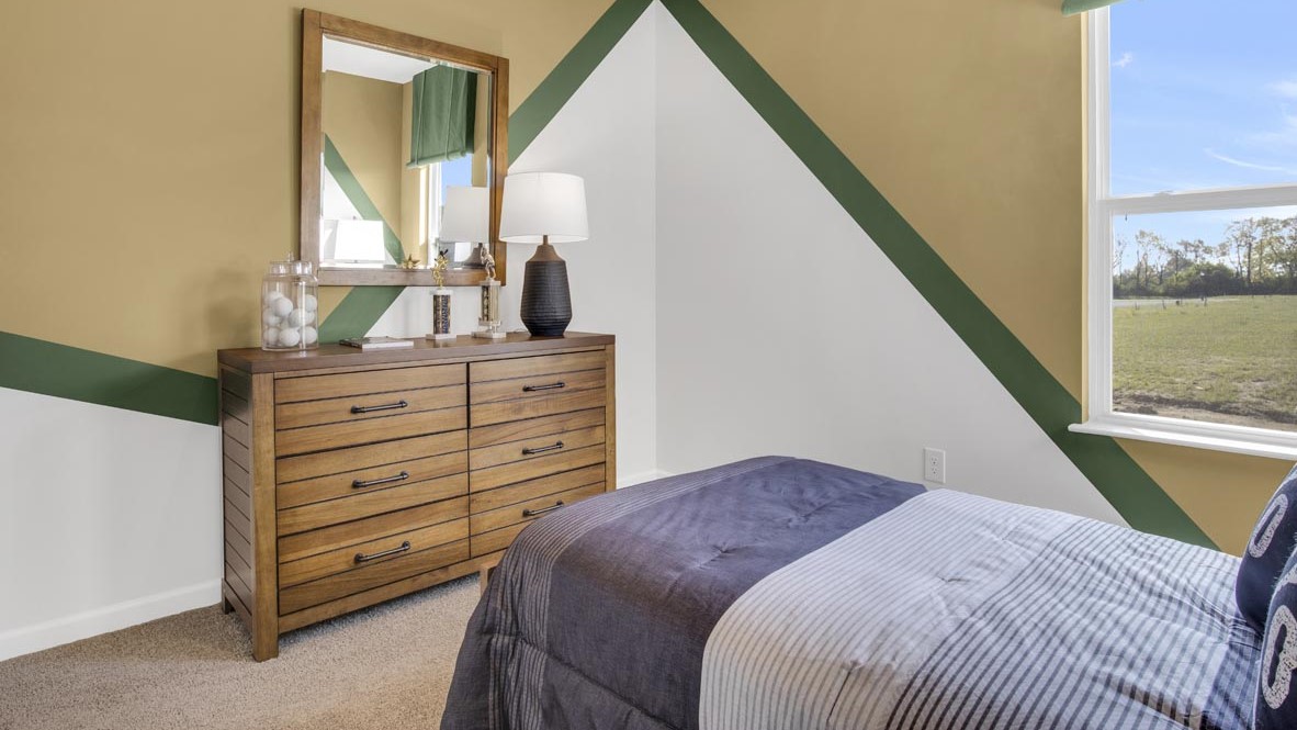 Lacrosse themed room with bed, wooden dresser and mirror.