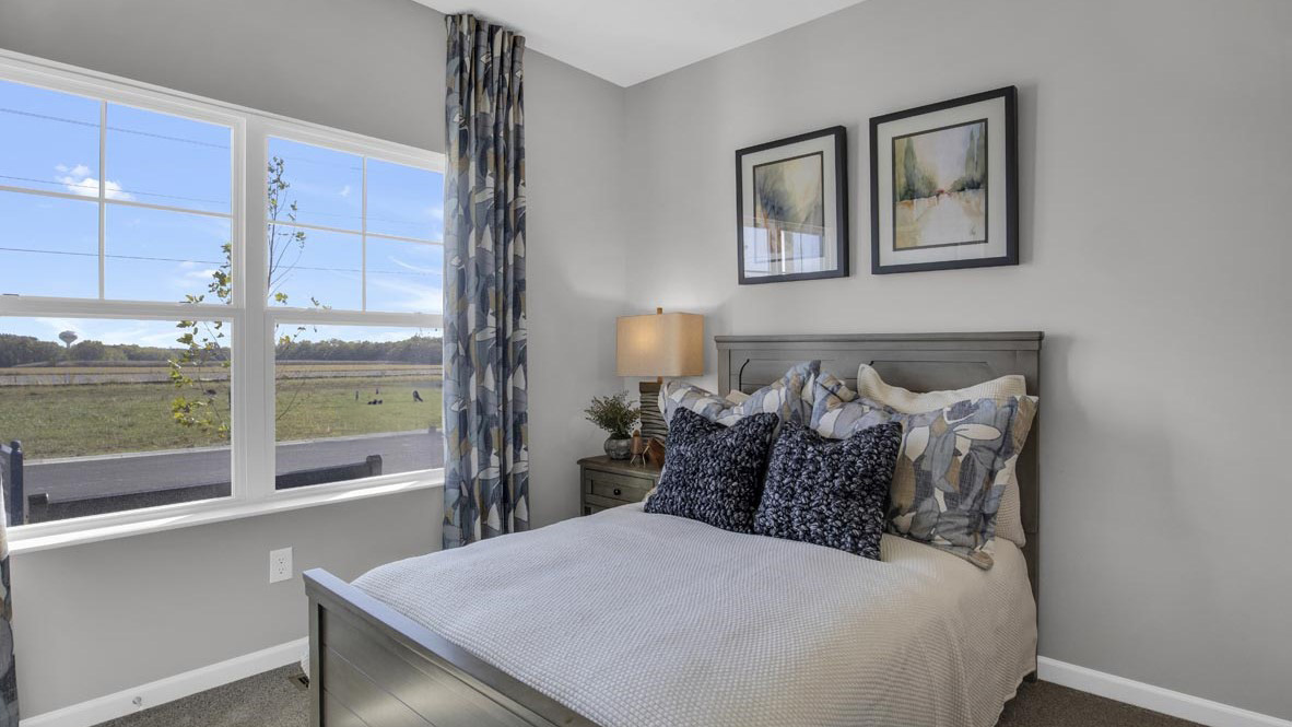 large wide windows with modern art and bed.