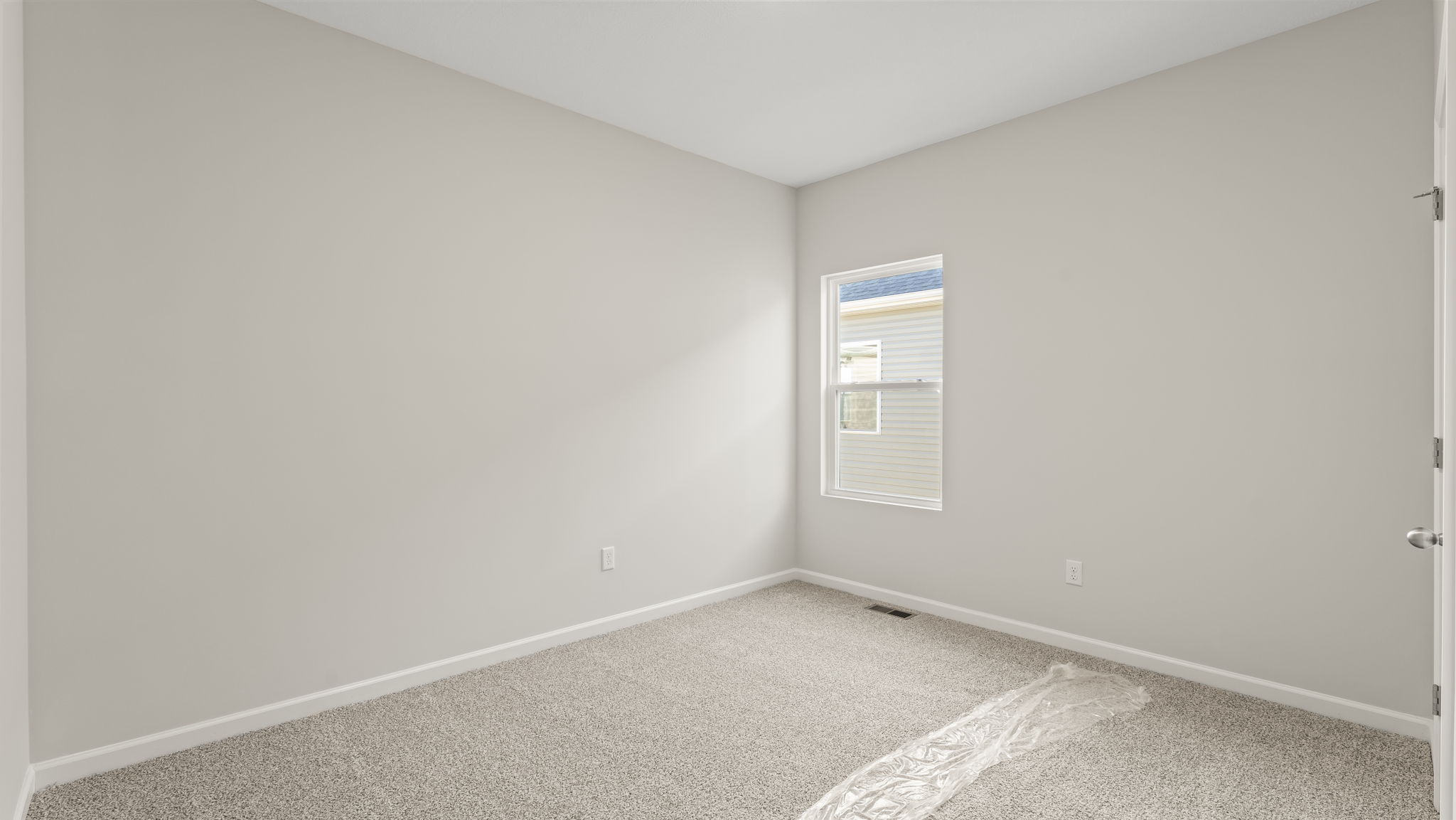 Carpeted bedroom with door to hallway