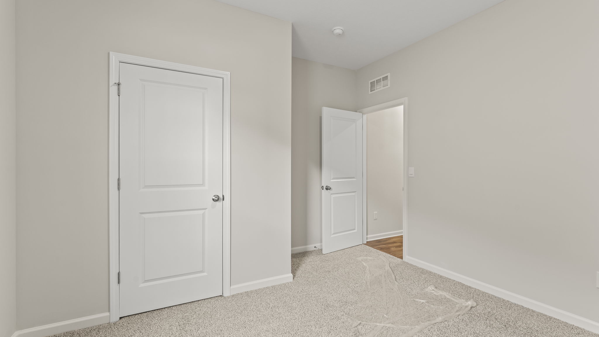 Carpeted bedroom with door to hallway