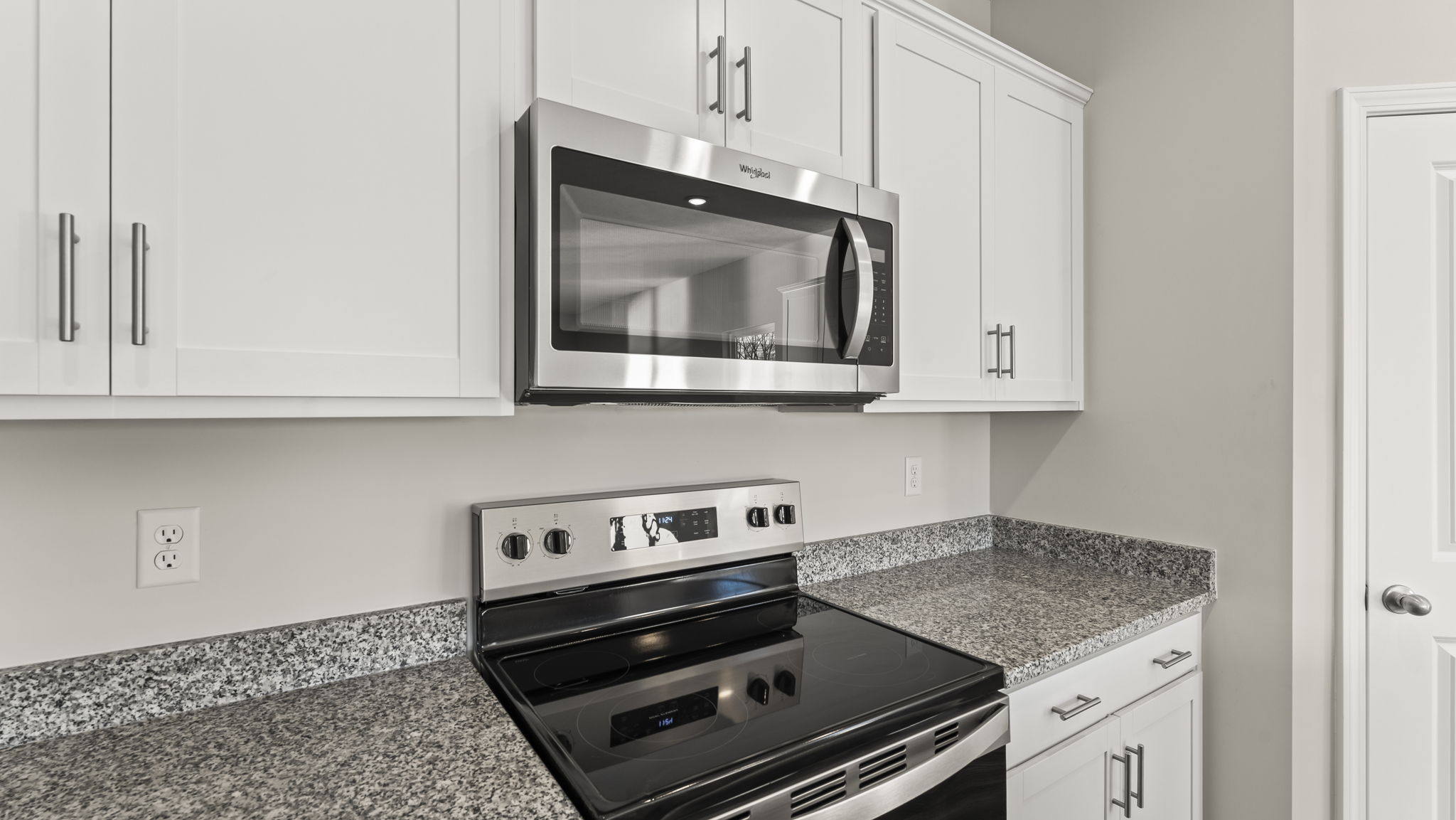 Closeup of oven range and microwave between cabinetry